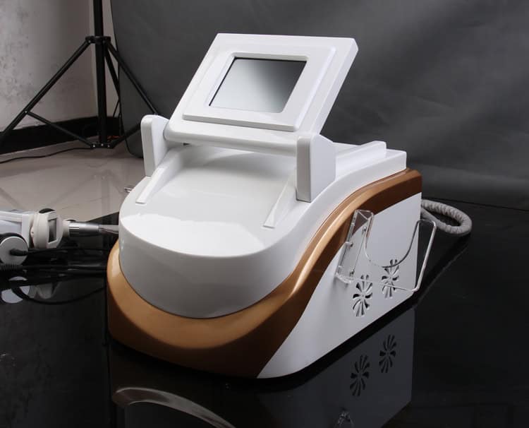 En vit och guld Beauty Distributors Radio Frequency + Cryogenics Lipo Cool Device för viktminskning på ett bord.