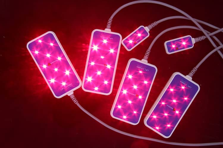 Sekelompok lampu LED merah dengan latar belakang merah yang memanfaatkan Mesin Velashape Terapi Vakum Lipo Kavitasi Frekuensi Radio Mengurangi Selulit untuk mengurangi selulit.