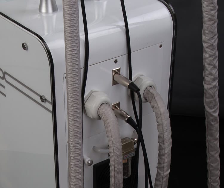 En närbild på en professionell skönhetsmaskin från fabriken Cryo Cool Lipo ismaskin för fettfrysning med två anslutna kablar.