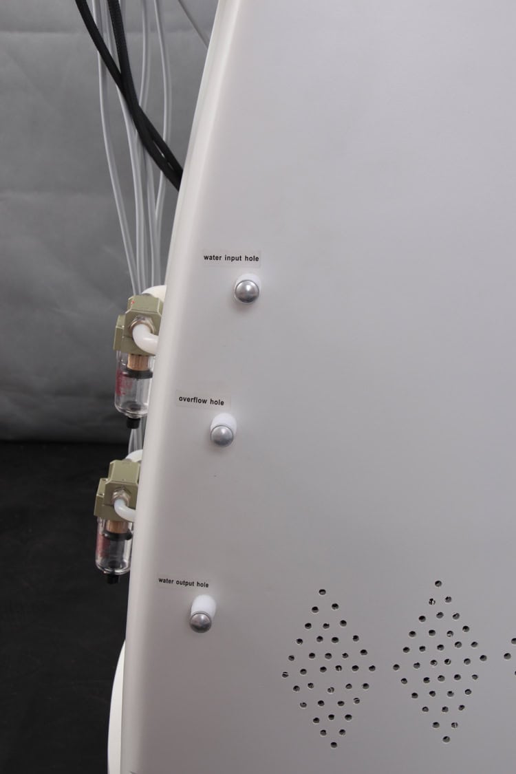 De achterkant van een witte Slimming Beauty 6 in 1 bodycontourmachine met twee draden eraan.