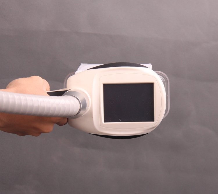 Uma pessoa em pé e segurando uma máquina de beleza para remoção de gordura em pé custa um equipamento de tratamento de crioterapia e congelamento com uma tela.