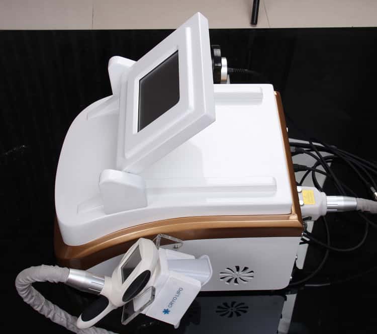Um dispositivo de radiofrequência + criogenia Lipo Cool de distribuidores de beleza branco e dourado para perda de peso em uma mesa.