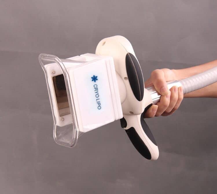 Uma pessoa em pé e segurando uma máquina de beleza para remoção de gordura em pé custa um equipamento de tratamento de crioterapia e congelamento com uma tela.