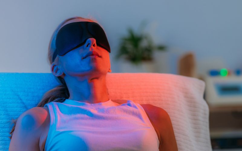 Relaxing woman with eye mask experiencing comfort and wellness in a cozy home setting, emphasizing sleep therapy and relaxation solutions for better sleep quality.