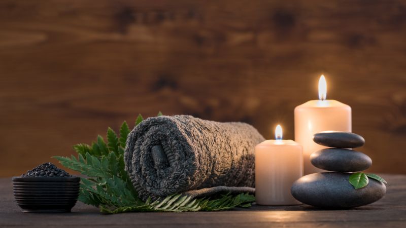 Soft plush towel, candles, and spa stones creating a relaxing, cozy atmosphere for comfort and wellness. Perfect for home relaxation, self-care, and spa moments.