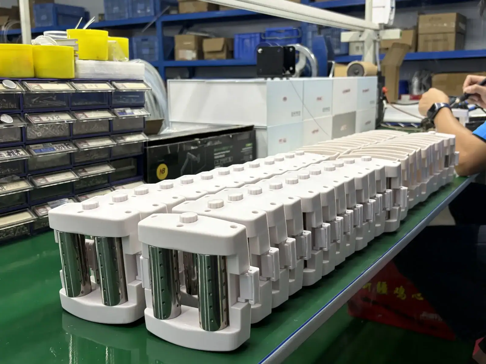 Close-up of a large industrial battery pack being assembled on a production line in a factory setting.