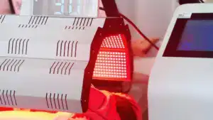 Close-up of OSANO PDT LED Light Therapy Machine emitting red light for skin treatment and rejuvenation.